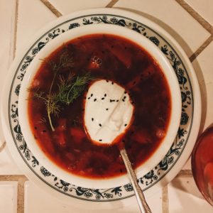 Bowl of homemade Russian borscht, made of beetroot giving it a distinctive red color.with a spoonful of sourcream
